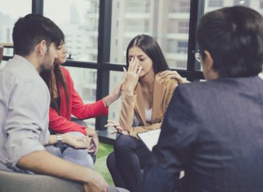 Mental health concept, group problematic young people talking with a guidance counselor. Group of therapy session sitting and talking. Diverse people talking, help and giving support.